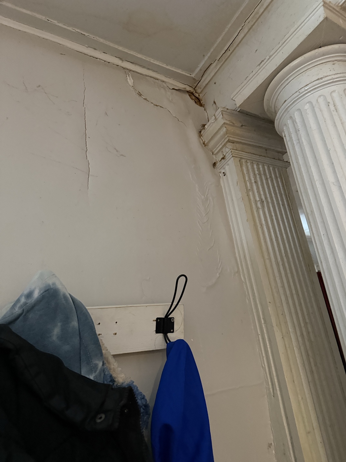 Cracking at the wall, ceiling, and decorative doorway trim before structural repairs at 1205 Spring Street